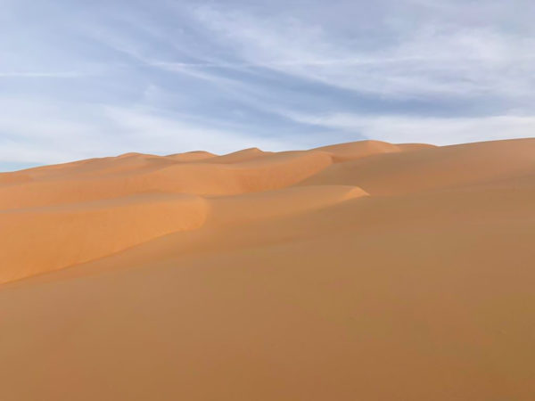 Pristine, sandy dunes form waves on the horizon